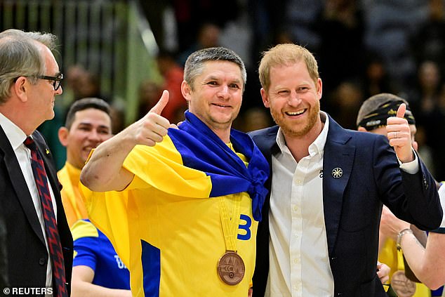 Harry reacts with a Ukrainian team member after they won the bronze medal in Sitting Volleyball