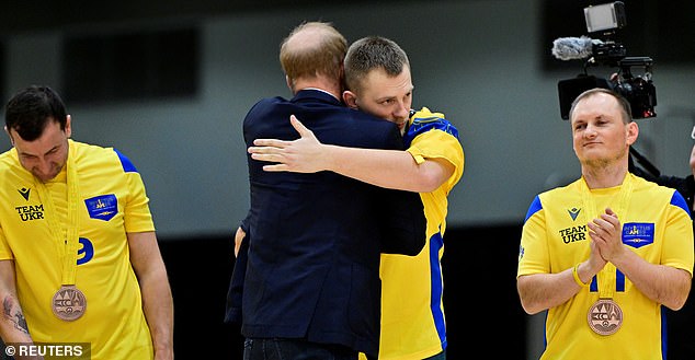 Harry embraces a Ukrainian team member after the team won the bronze medal in Sitting Volleyball