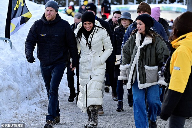 Harry and Meghan stood and watched the event but after posing for photos with spectators left for the warmth of their SUV cars