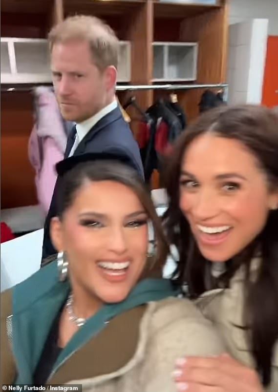 A serious Prince Harry nonchalantly walked in the background, leading to the pair to crack up with laughter and blow kisses