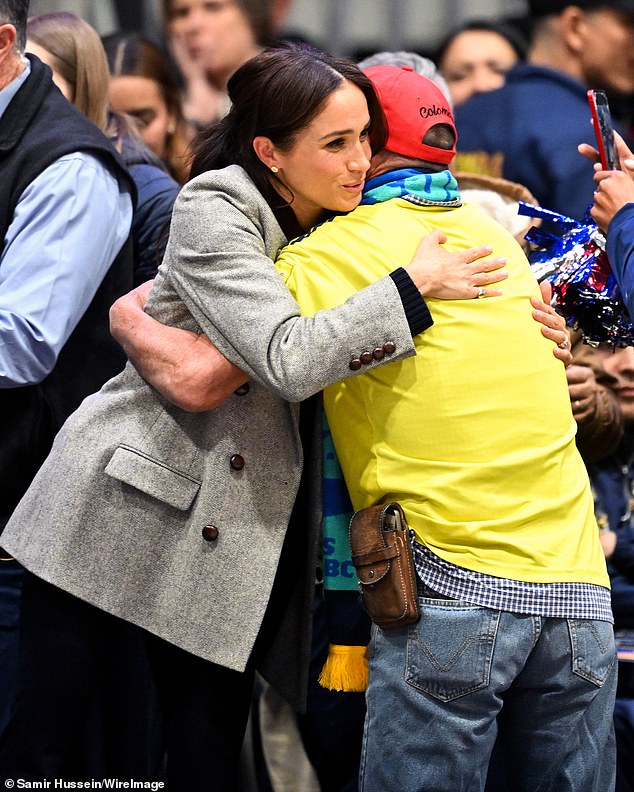 Meghan shares a hug with a well wisher during the wheelchair basketball match yesterday