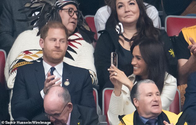 Viewers tuning into the Invictus Games that are currently underway in Canada joked that Meghan was in full influencer mode as she filmed close-ups of Prince Harry while the couple watched the opening ceremony in Vancouver