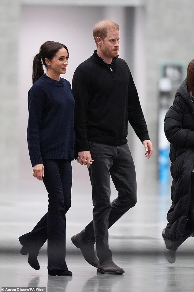 As the game progressed, the mother-of-two took off the jacket to reveal a navy crewneck sweater from one of Meghan's favourite brands, La Ligne, that sells for around £260