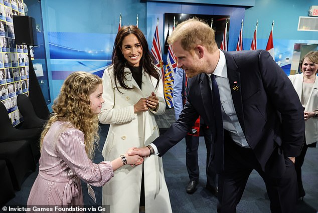 Meghan smiled as she watched her husband greet attendees at the BC Sports Hall of Fame in Vancouver