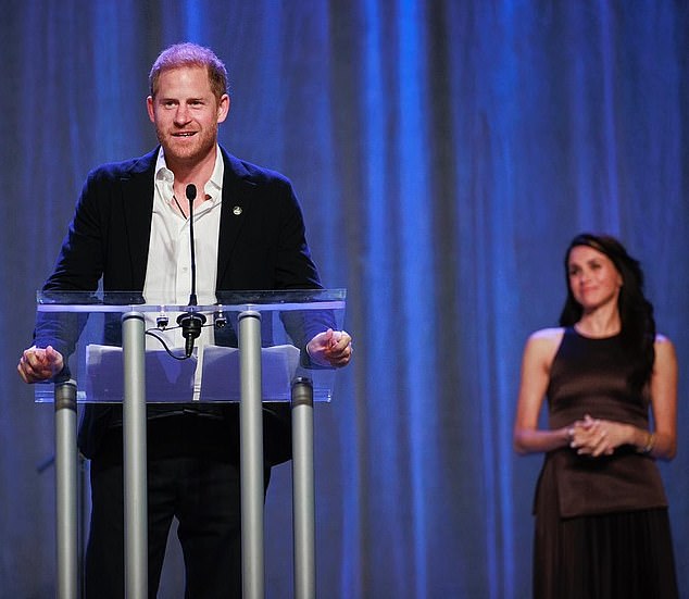 Meghan donned a £678 'Willow' Pleated Midi Dress in 'Chocolate' from A.L.C. as she adoringly watched her husband Prince Harry as he opened the seventh edition of the Invictus Games