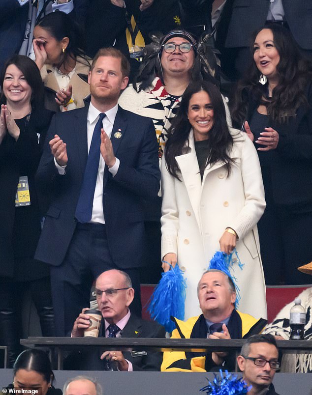 Meghan added to her paired-down look with her engagement ring and wedding ring, a diamond eternity band alongside a pair of simple stud earrings