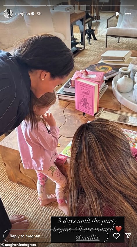 In another photo Meghan, dressed in a navy blue pyjama set with white pin stripes, leans over Lilibet with a Candy Land pink box arefully positioned on a table in front