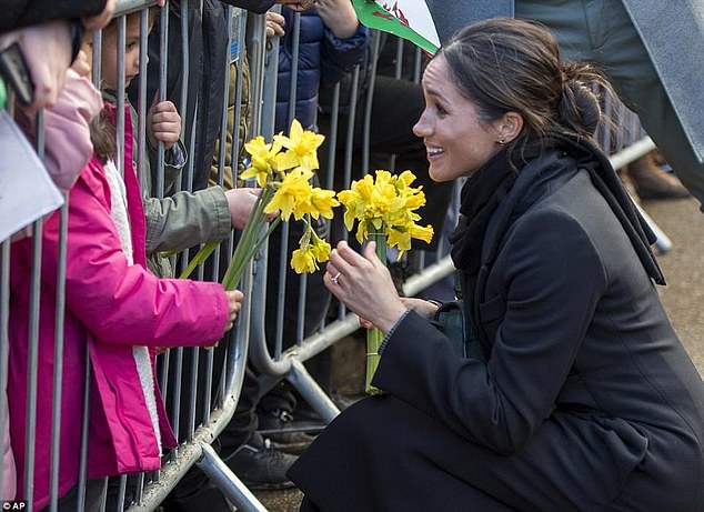 Children passed flowers to Meghan through the barrier when she visited Wales in 2018