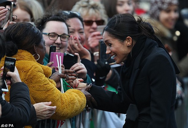 Hundreds of people greeted Harry and Meghan in Cardiff, waving Welsh flags