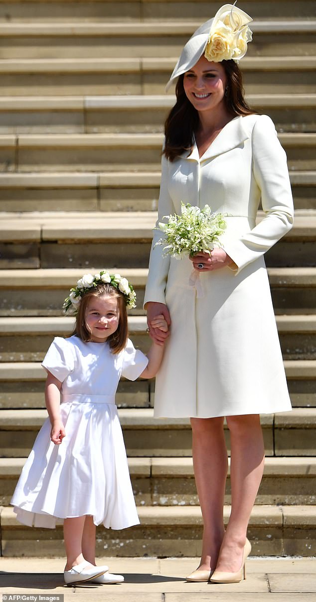 Catherine stands with her daughter Princess Charlotte as they leave the wedding of Harry and Meghan at St George's Chapel in 2018