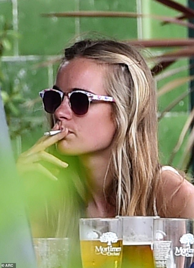 Cressida Bonas lights up at a bar in London in July 2014 - months after she called it quits with Prince Harry