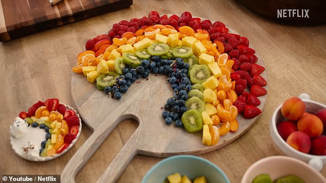 'It makes the morning a lot more fun', said the mother-of-two, before adding: 'Can I just show you? If you just made one.' While building the smaller rainbow-themed fruit salad (pictured alongside the bigger version), Prince Harry's wife insisted: 'It's a real delight in being able to be a present parent'