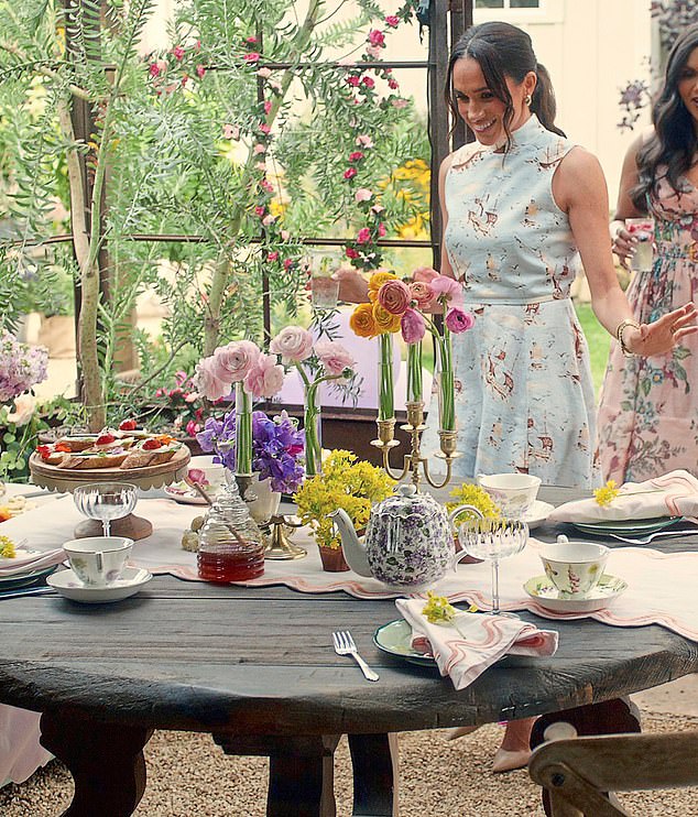 In this shot, a beaming Meghan is seen sporting a colourful Emilia Wickstead 'Sheila' boat print dress thought to be worth around £856