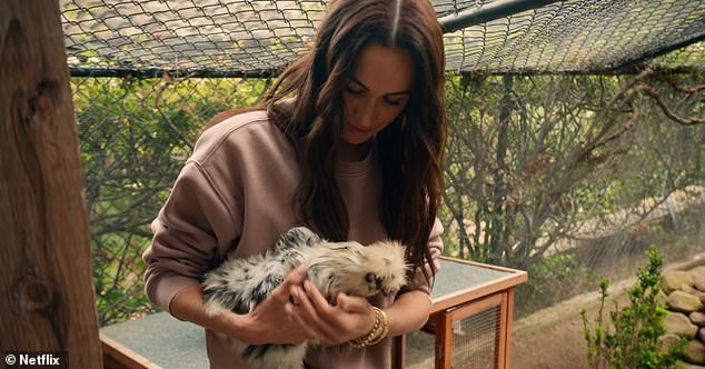 Meghan holds a chicken during an episode of her new Netflix show which came out today