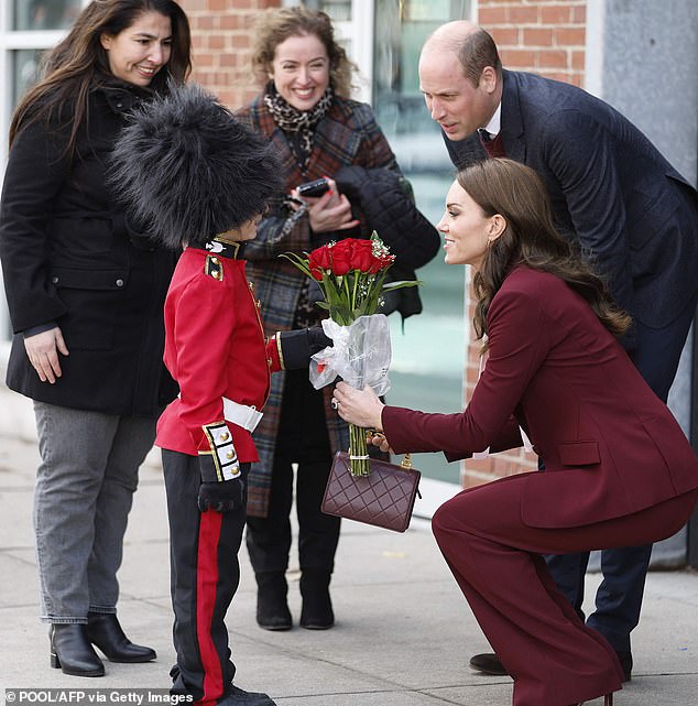 Catherine, Princess of Wales, receives flowers from a boy dressed as a King's Guard during a visit to Boston, Massachusetts, in December 2022