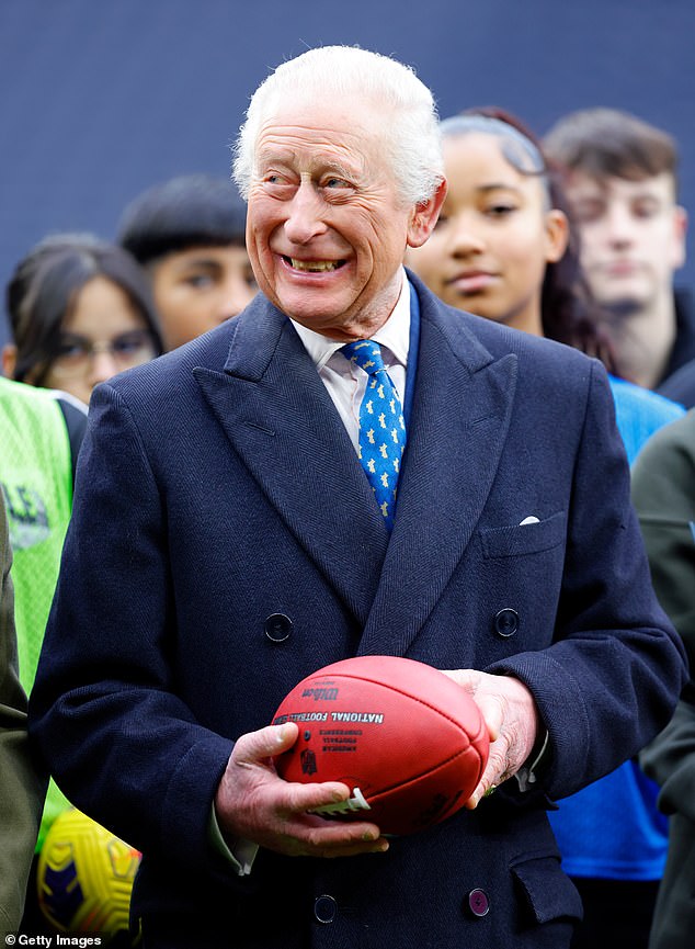 King Charles III is presented with an American football from Super Bowl LIX, which took place between the Philadelphia Eagles and the Kansas City Chiefs in New Orleans, during a visit to Tottenham Hotspur Stadium on February 12, 2025