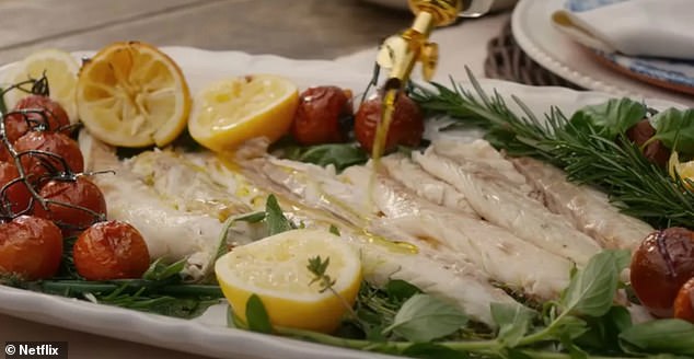 The Duchess of Sussex served her fish with a dash of oil, lemons, roasted on the vine tomatoes and lots of fresh herbs (pictured)