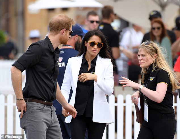 Prince Harry and Meghan with her assistant Amy Pickerill in Sydney. A royal insider has revealed that behind the glittering success of the tour tensions were already starting to rise between the couple and their royal aides