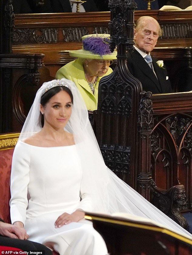 Philip is seen looking over at Meghan on her wedding day, with the Queen sitting next to him