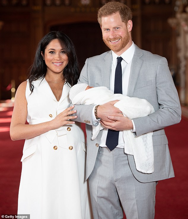 Harry and Meghan pose with their newborn son Archie Harrison Mountbatten-Windsor during a photocall in St George's Hall at Windsor Castle on May 8, 2019