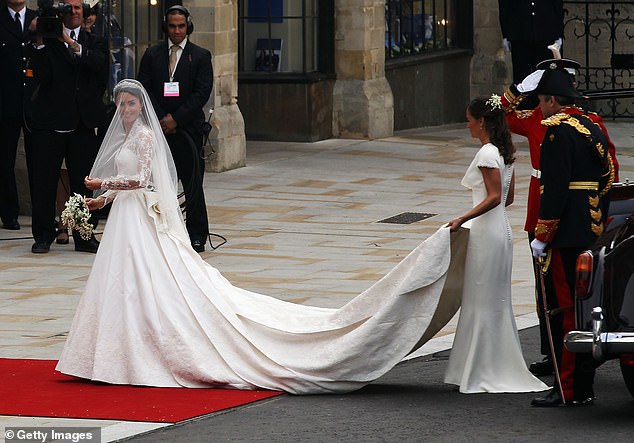 The ivory dress featured handmade lace created by the Royal School of Needlework, and a train stretching almost nine-feet in length