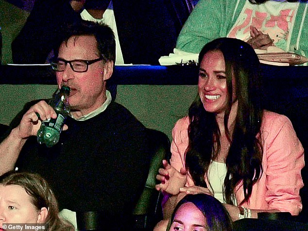 Meghan in a LA Lakers box with Rick Genow, who is co-chair of the black tie bash next weekend that will honour the Duchess of Sussex