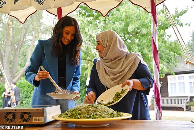 Meghan is pictured helping to prepare food at the cookbook launch at Kensington Palace