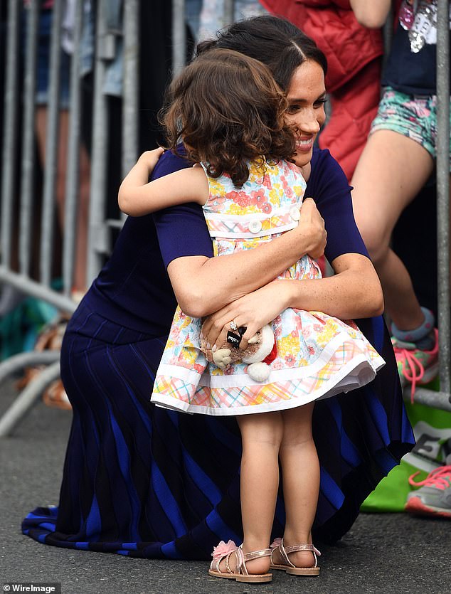 Tina Brown wrote: 'Meghan was photographed in full Diana mode, hugging toddlers who gave her flowers'