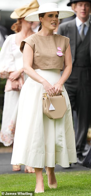 Putting on a chic display, Eugenie stunned in a stylish wide-brimmed hat and flattering dress featuring a billowing white skirt and a square-shouldered brown top