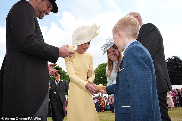 The Prince and Princess of Wales received Jellycat soft toys and met the family of Liz Hatton, mother Vicky Robayna, father Aaron and brother Mateo (pictured shaking Kate's hand), at a Buckingham Palace Garden Party in May